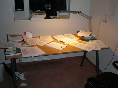 This image is of a student’s desk covered in books and papers